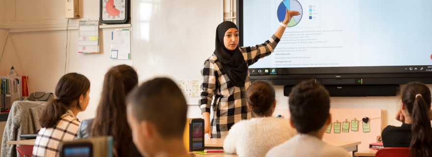 Vrouwelijke docent met hoofddoek geeft les op een islamitische school in Leiden