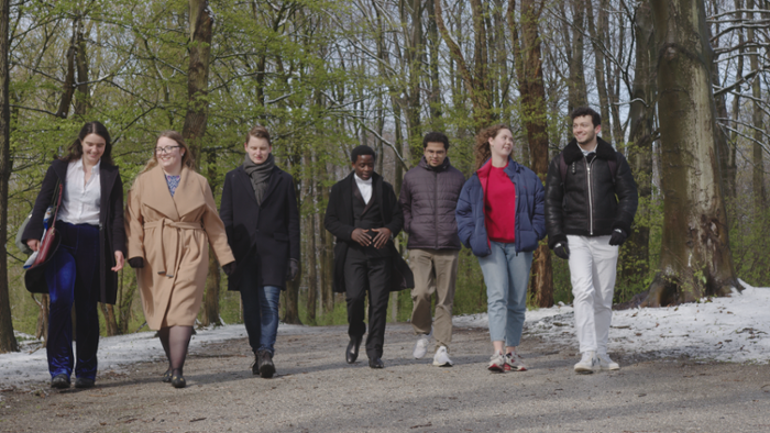 Ayo Adedokun walking in the woods with a group of students.
