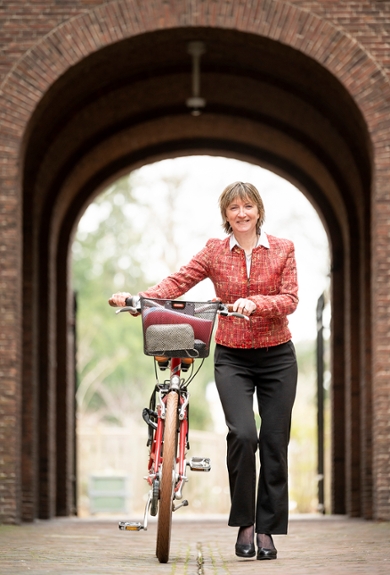 Annetje Ottow loopt met haar fiets door Leiden