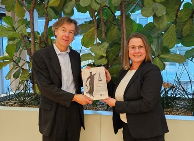 Esther Huiskers-Stoop hands her report to Jasper Wesseling, Director General of Tax Affairs